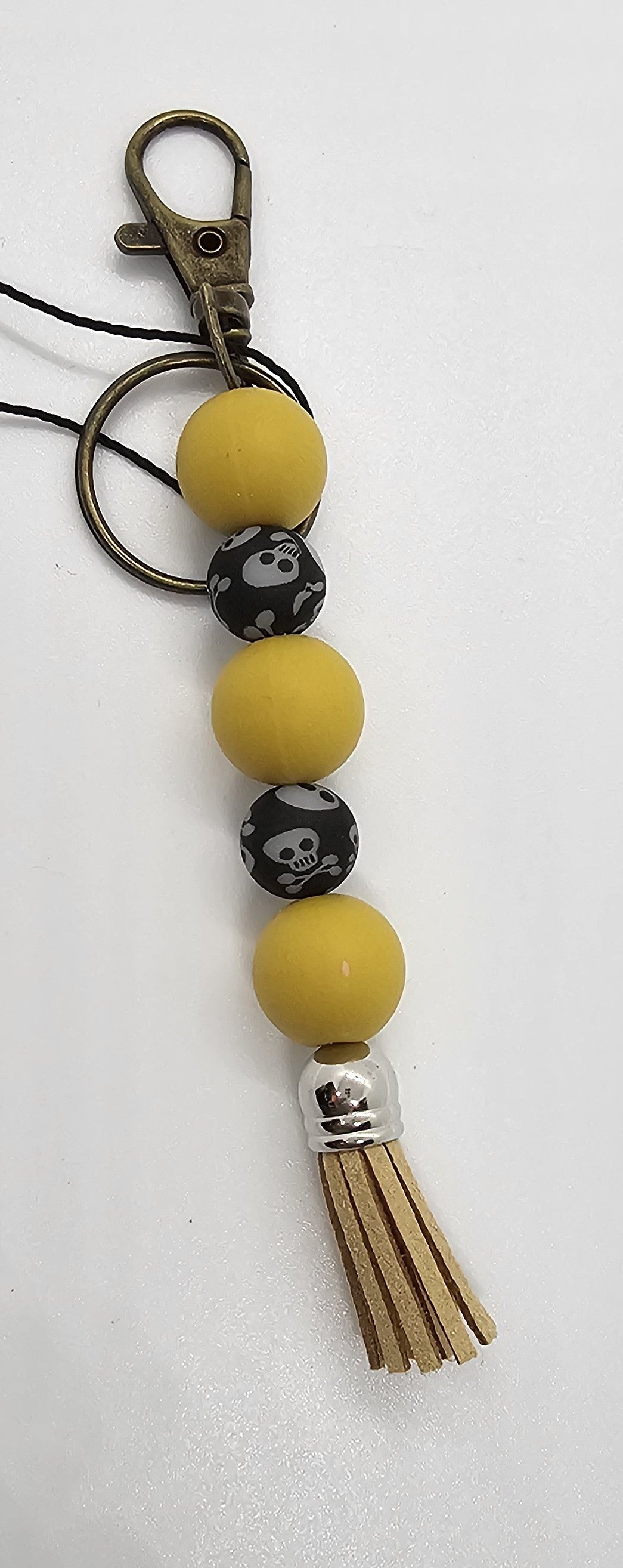 Mustard and skulls glow keychain