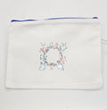 White pouch with floral and butterfly design on a white background