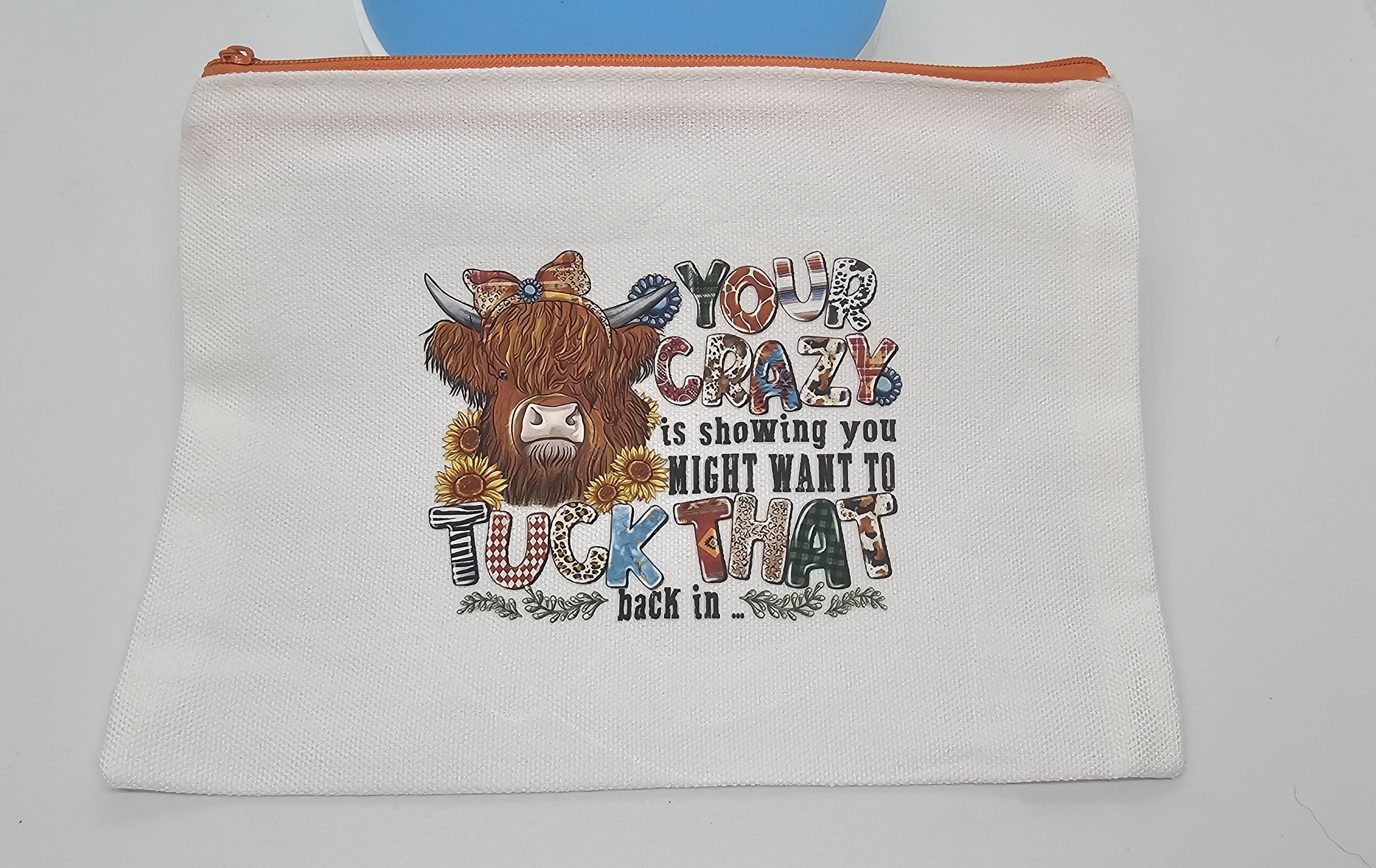 White pouch with a colorful design of a cow and text on a white background